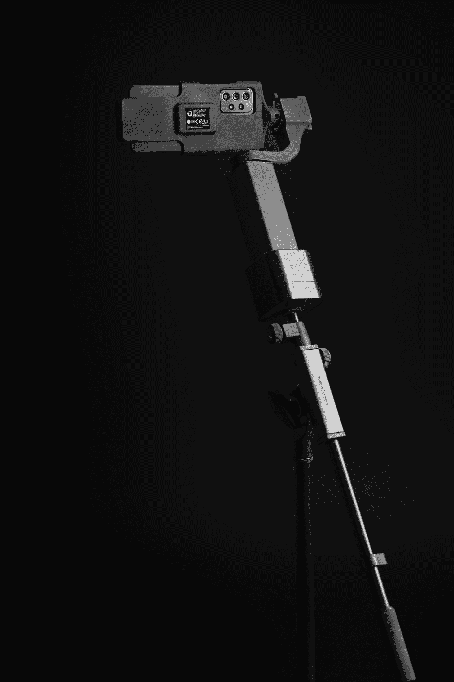Gimbal with smartphone inside a stand on black background
